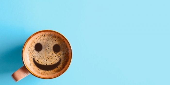 cup of delicious hot coffee with foam and smile on color background, top view happy morning, good mood, inspiration space...