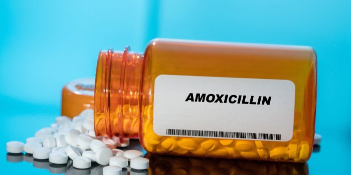 amoxicillin white medical pills and tablets spilling out of a drug bottle macro top down view with copy space