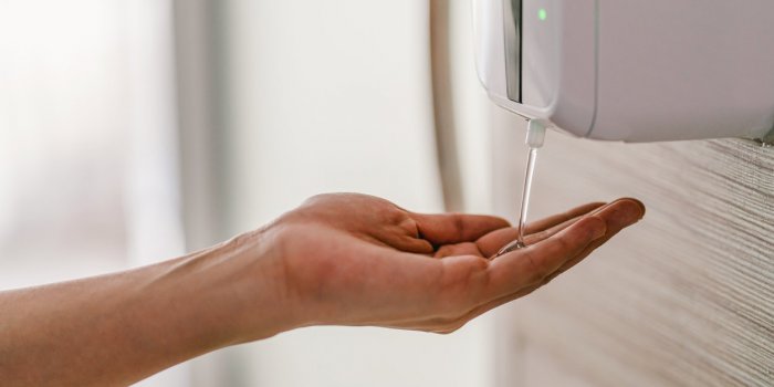 asian woman hand using wash hand sanitizer gel dispenser automatic machine for prevent coronavirus