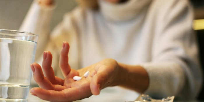 close up of woman hands holding a pills