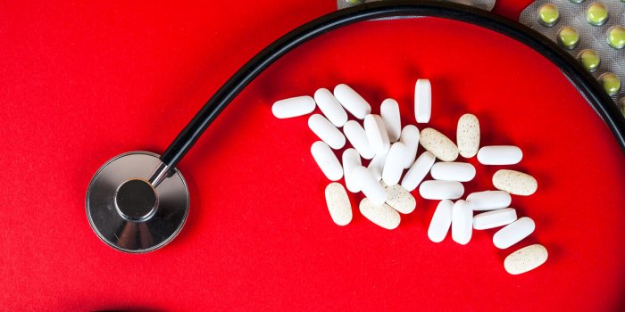 pills ,tablets and stethoscope on red background pharmaceutical medicament, cure in container for health antibiotic, pain...