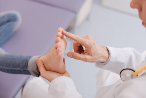 experts touch wonderful attentive caring doctor making sure his patients reflexes working right while toughing her feet