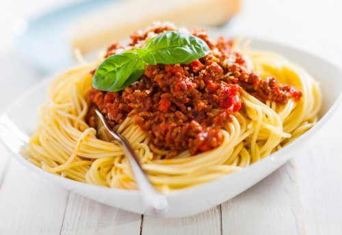 bowl of delicious italian spaghetti bolognese topped with a rich meat and tomato sauce and sprinkled with grated parmesan...