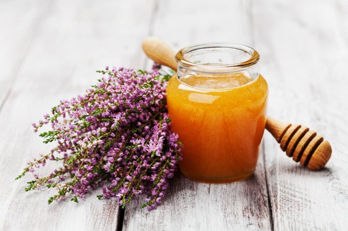 delicious fresh honey in pot or jar and flowers heather on wooden vintage shabby background