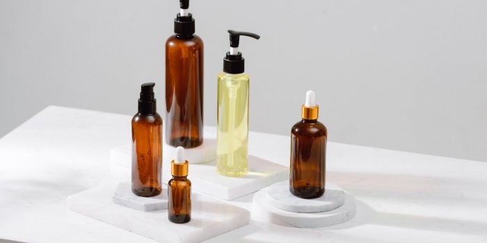spa cosmetics in brown glass bottles on gray concrete table copy space for text beauty blogger, salon therapy, branding m...