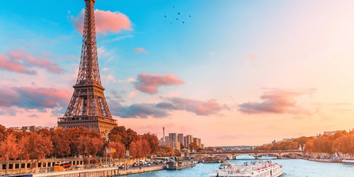 the main attraction of paris and all of europe is the eiffel tower in the rays of the setting sun on the bank of seine ri...