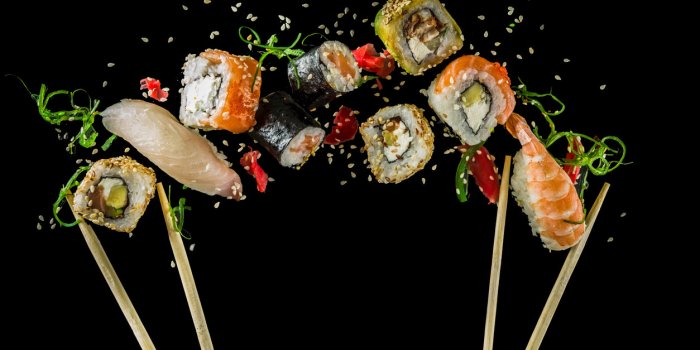 seamless pattern with sushi food abstract background flying sushi, sashimi and rolls isolated on the black background