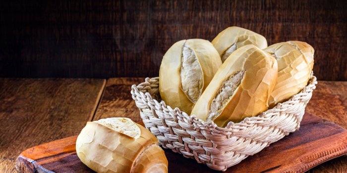 several traditional breads from brazil, on a rustic wooden background in a straw basket national day of brazilian french ...