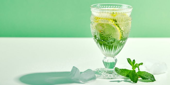 summer drink, fresh lemonade with mint, lemon and ice in wine glass mint infused water, alcoholic or non-alcoholiccocktai...