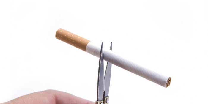 detail of cigarette cut with the hand scissors stop smoking concept