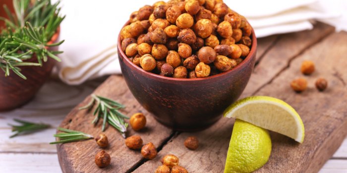 traditional indian cuisine roasted spicy chickpeas with lime and rosemary on rustic wooden background copyspace, horizont...