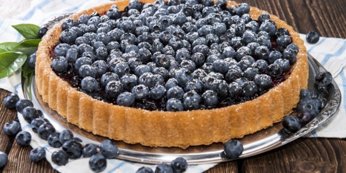 blueberry tart with fresh fruits on vintage wooden background