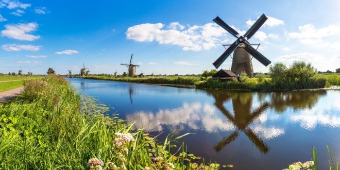 windmills and water canal in kinderdijk in a beautiful summer day, holland
