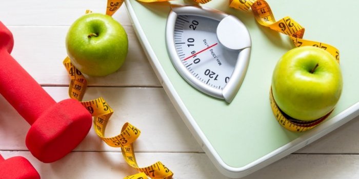 diet and healthy life loss weight concept green apple and weight scale measure tap with fresh vegetable and sport equipme...