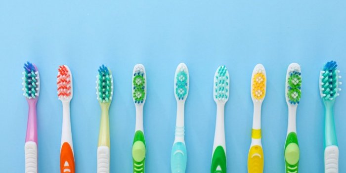 many tooth brushes on color background