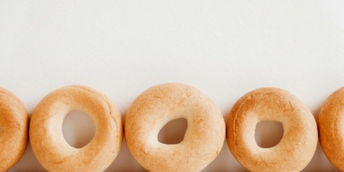 drying or mini round bagels on a white wooden background copy, empty space for text