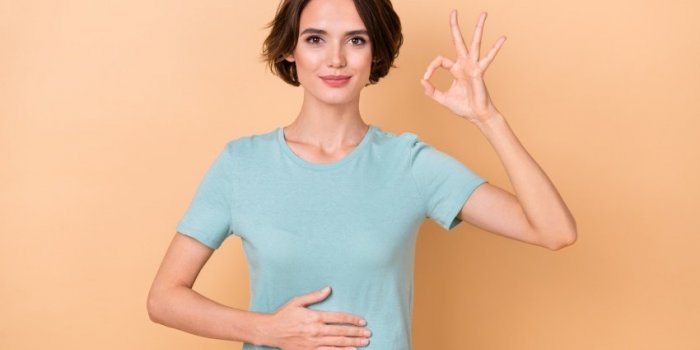 photo of young lady arm on belly show fingers okey symbol good promo isolated over beige color background