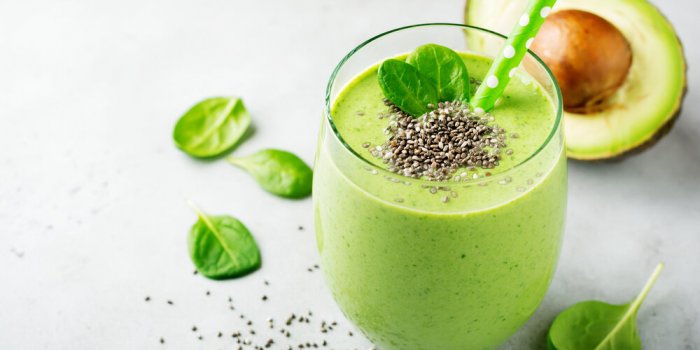 vegetarian healthy green smoothie from avocado, spinach leaves, apple and chia seeds on gray concrete background selectiv...