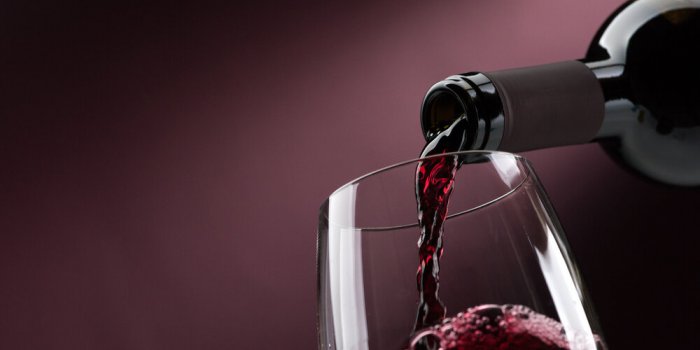 pouring red wine from a bottle into a wineglass wine tasting and celebration