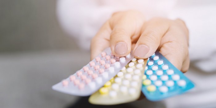 close up hand contraceptive pill on with colorful pills strips