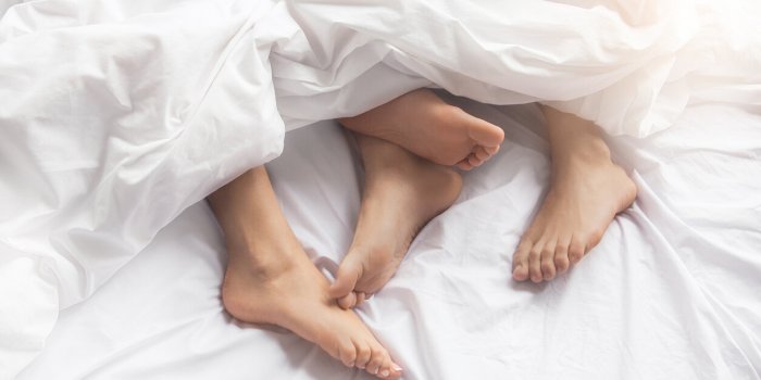 young couple man and woman intimate relationship on bed feet