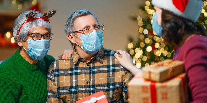 people with gifts wearing facemasks during coronavirus and flu outbreak on christmas virus and illness protection, home q...