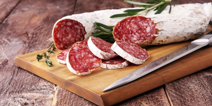 marble cutting board with sliced salami on it
