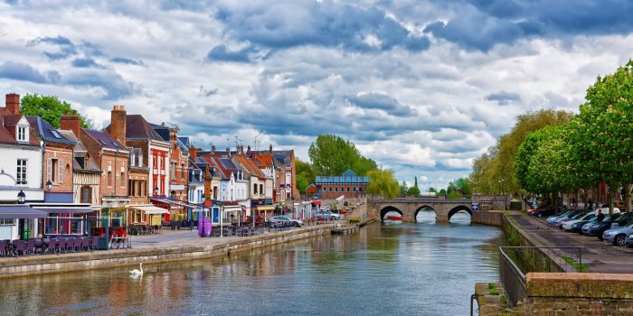amiens, france - may 9, 2012 quay of belu with traditional houses and somme river in amiens, picardy, france people on t...