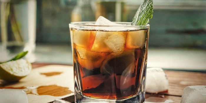 glass of rum on the wooden background, cuba libre or long island iced tea cocktail with strong drinks, cola