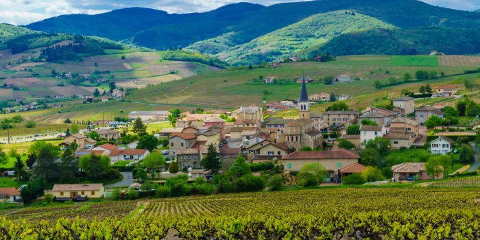 landscape of vineyards and countryside in beaujolais, with the village lantignie rhone department, france