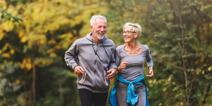 smiling senior couple jogging in the park