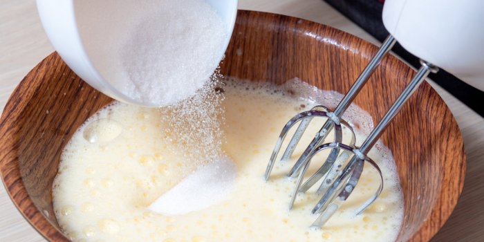 adding sugar in the process of beating eggs with an electric mixer the cooking process selective focus