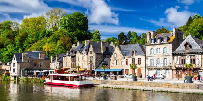 beautiful view of scenic narrow alley with historic traditional houses and cobbled street in an old town of dinan with bl...