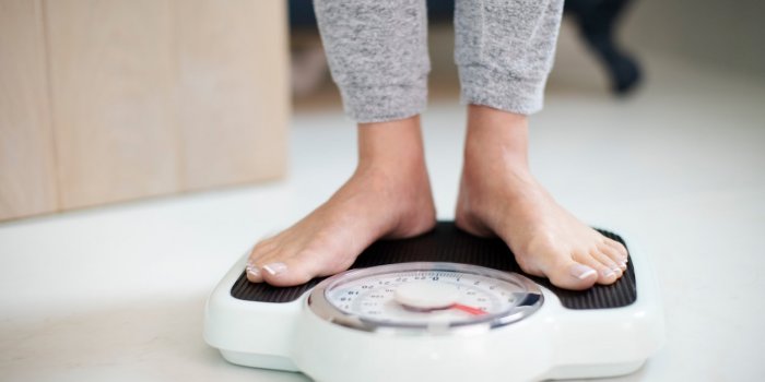 close up of woman standing on bathroom scales at home