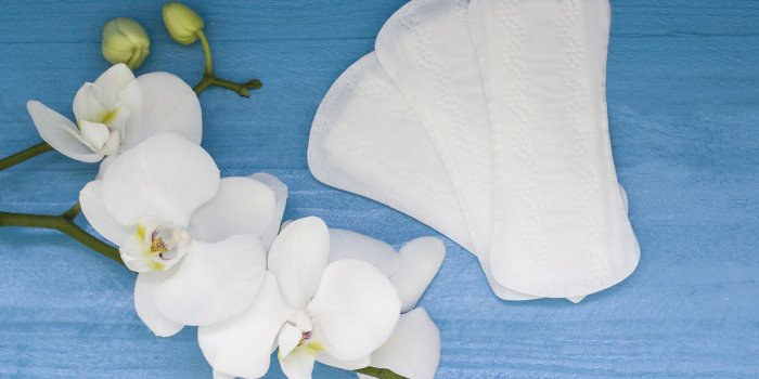 sanitary pads and lilac orchid on the blue wooden background