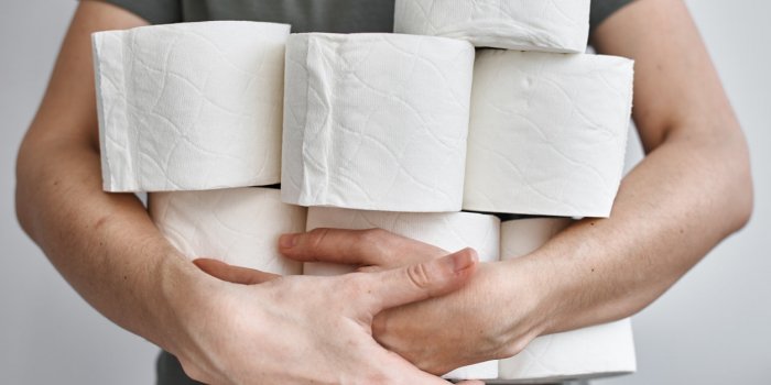 people are stocking up toilet paper for home quarantine from crownavirus woman holds many rolls of toilet paper
