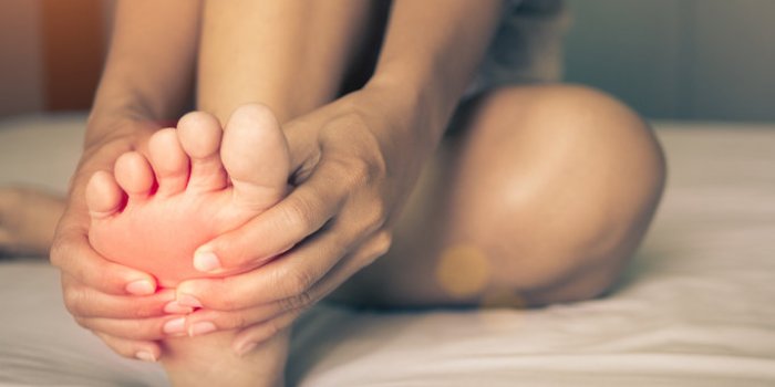 health care concept woman massaging her painful foot, red hi-lighted on pain area