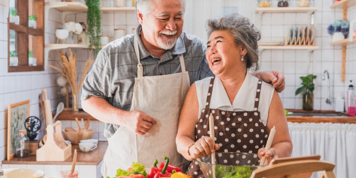lovely couple asian elder happy and smiling cooking salad together for breakfast in the morning at home kitchen