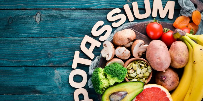 foods containing natural potassium k potatoes, mushrooms, banana, tomatoes, nuts, beans, broccoli, avocados top view on ...