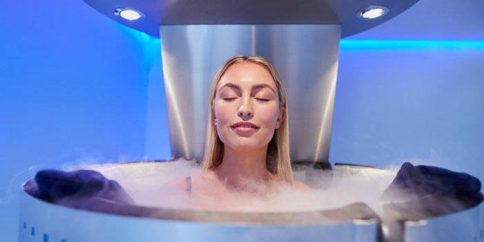 portrait of happy young woman in a whole body cryotherapy cabin with her eyes closed cryosauna chamber for overall increa...