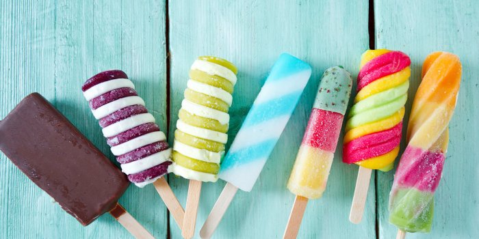 Colored popsicle ice cream on a turquoise wood background