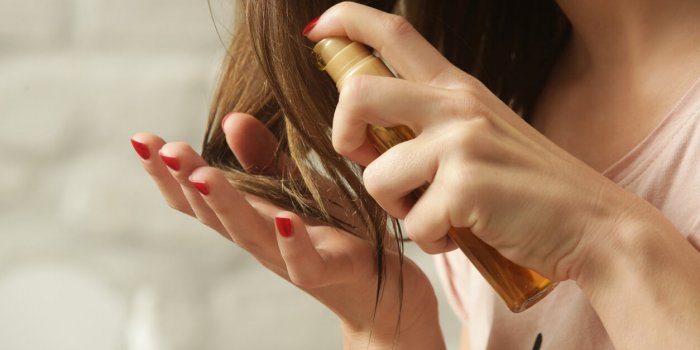 hair care woman applying oil on hair ends split hair tips, dry hair or sun protection concept