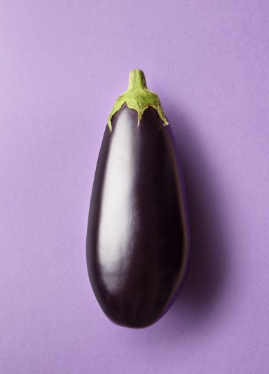 whole eggplant on a purple background viewed from above top view of an aubergine copy space