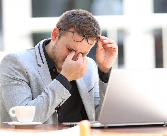 fatigue executif souffrant de fatigue oculaire travaillant en ligne assis dans un cafe