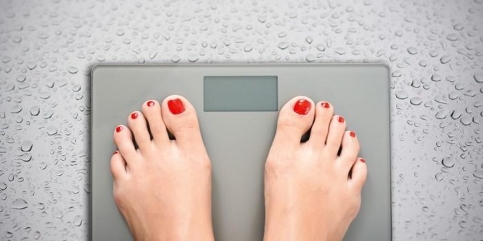 aider à perdre des kilogrammes avec des pieds de femme marchant sur une échelle de poids