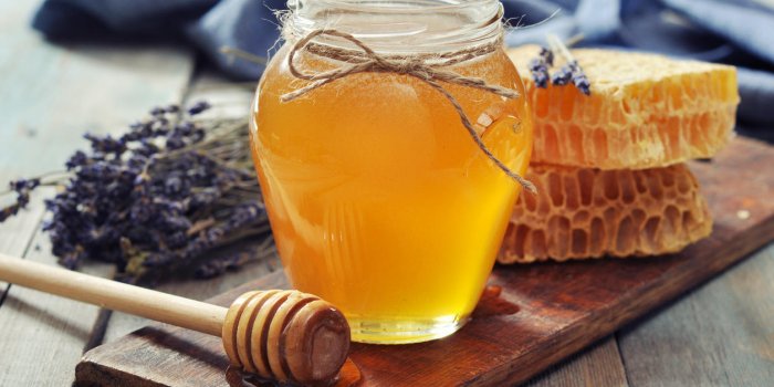 miel en pot avec une louche de miel sur fond en bois vintage