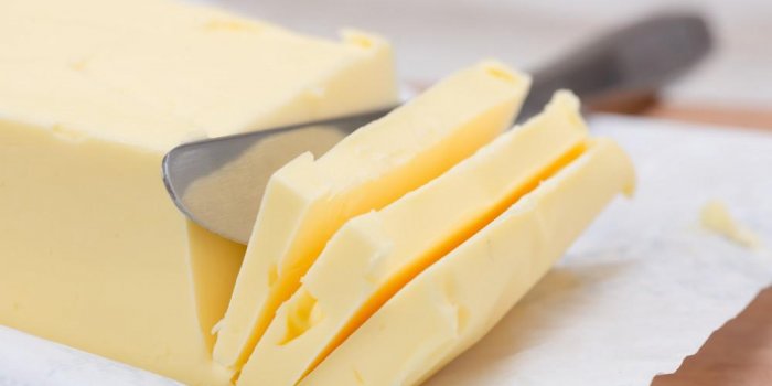 beurre frais en forme de barre sur une table et un couteau