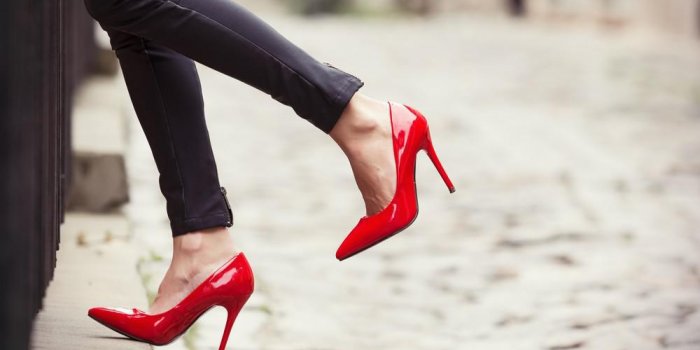 femme portant un pantalon en cuir noir et des chaussures à talons hauts rouges