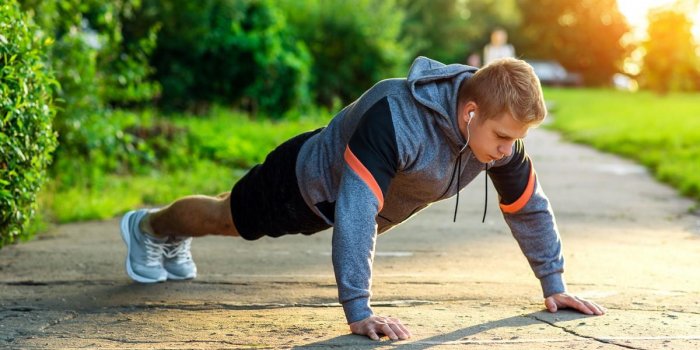 male athlete exercising in the park portrait of a male guy doing push-ups the concept of a healthy lifestyle strength and...