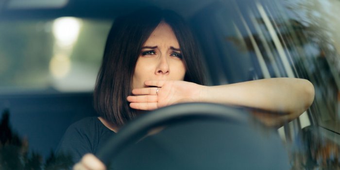 sleepy female driver yawning behind the wheel